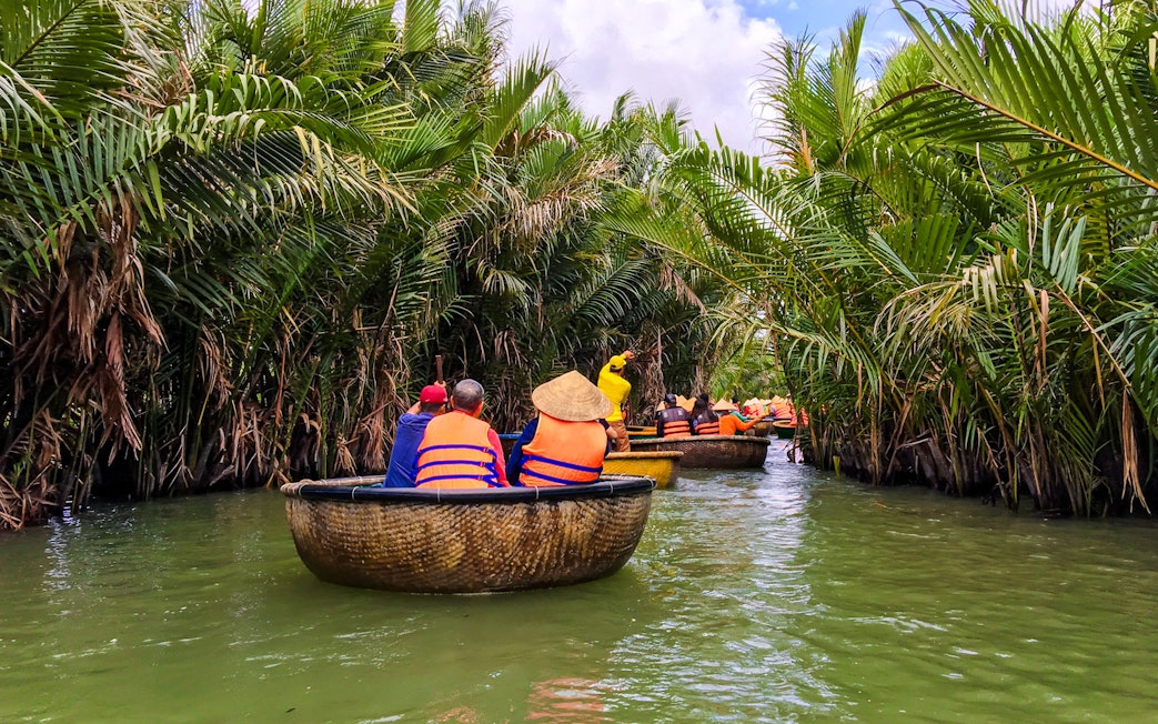 Tourists navigating a river in bamboo basket boats, Hoi An, Vietnam.