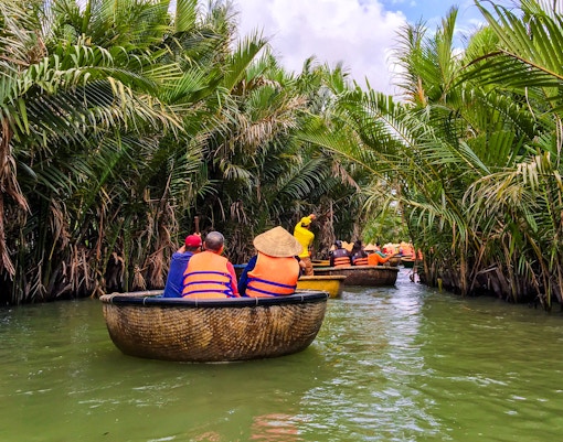 Tourists navigating a river in bamboo basket boats, Hoi An, Vietnam.