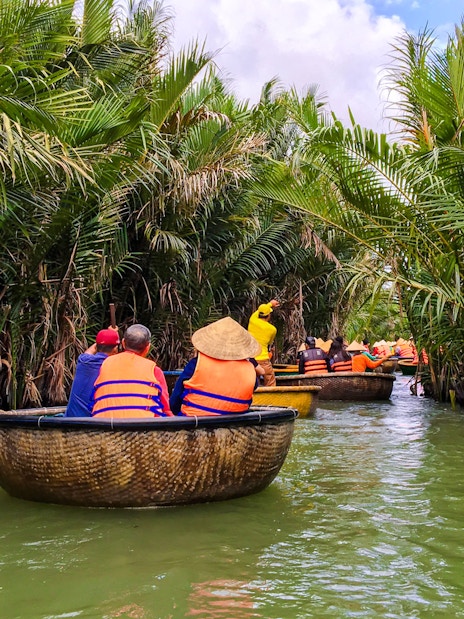 Tourists navigating a river in bamboo basket boats, Hoi An, Vietnam.