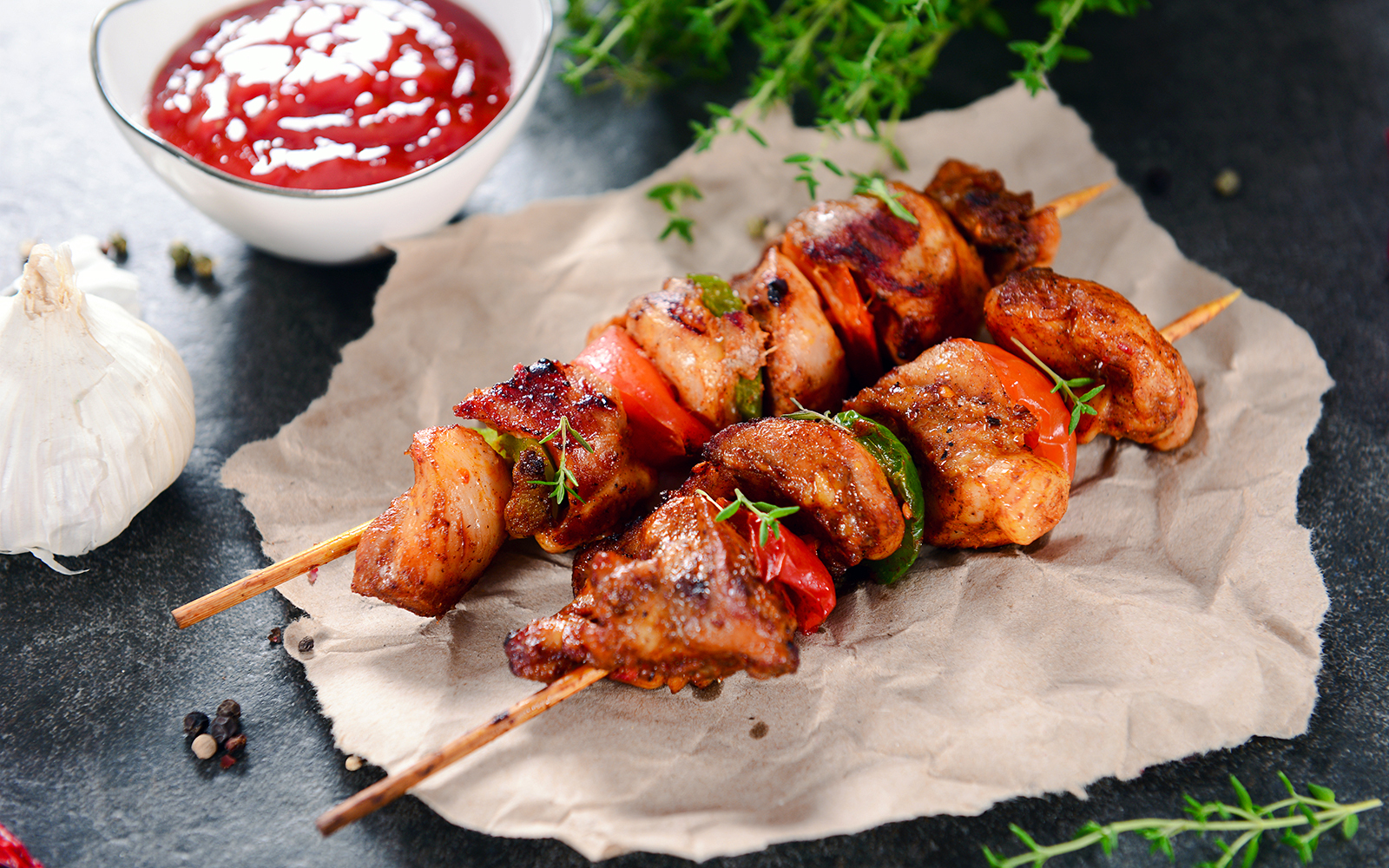 Chicken skewers with peppers and herbs, served with sauce in Portugal.