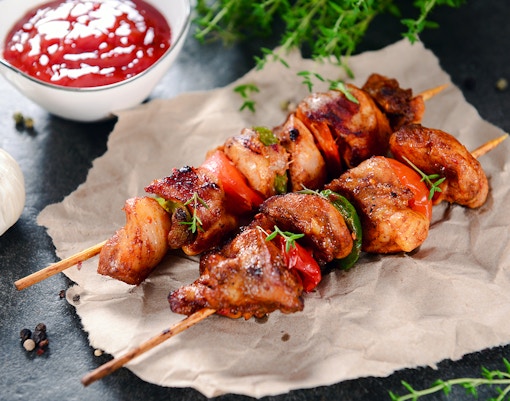 Chicken skewers with peppers and herbs, served with sauce in Portugal.