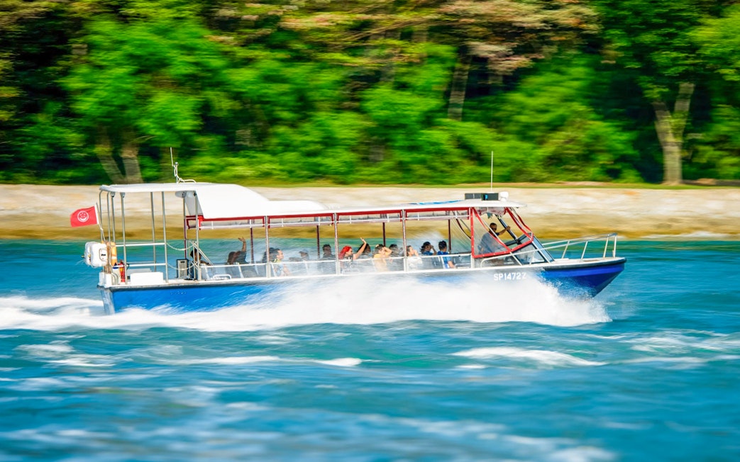 Speedboat with passengers cruising through water on Singapore Speedboat Adventure.