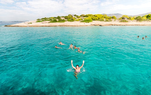 Group swimming in turquoise waters of Saronic Gulf, Greece.