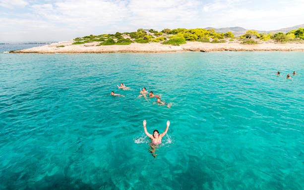 Group swimming in turquoise waters of Saronic Gulf, Greece.