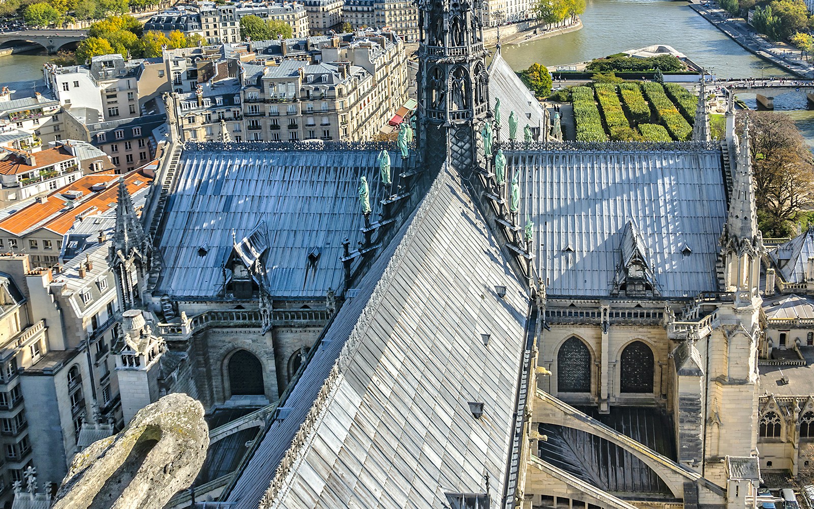 Vista do telhado da Catedral de Notre-Dame com o horizonte de Paris ao fundo.