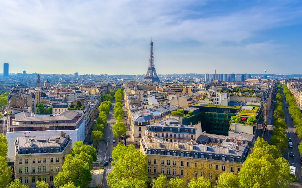 View of the Eiffel Tower from the Arc de Triomphe, Paris skyline in foreground.