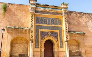 Historic gate in Meknes, Morocco with intricate tilework and archway.