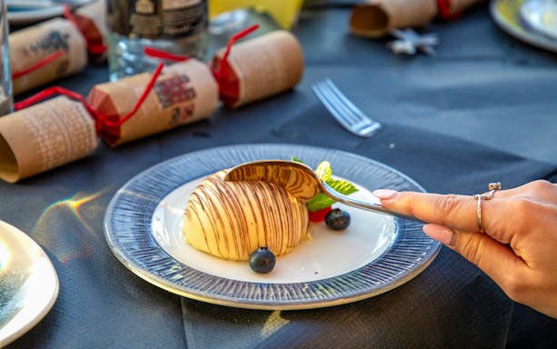 Dessert with chocolate drizzle and berries at Christmas lunch on Thames River cruise.