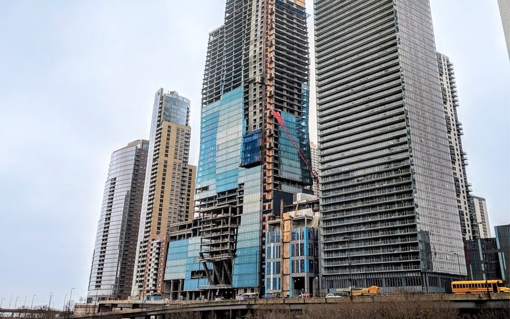 St Regis building under construction in Chicago with surrounding skyscrapers.