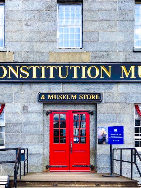USS Constitution Museum entrance with red doors and patriotic bunting.