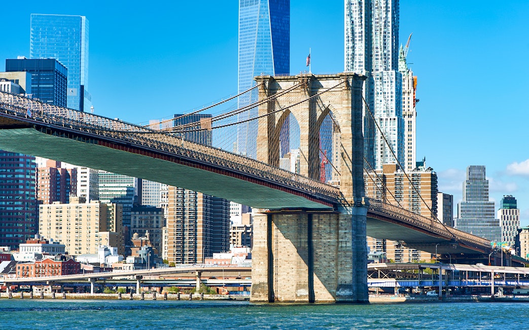 Brooklyn Bridge spanning East River with Manhattan skyline in New York City.