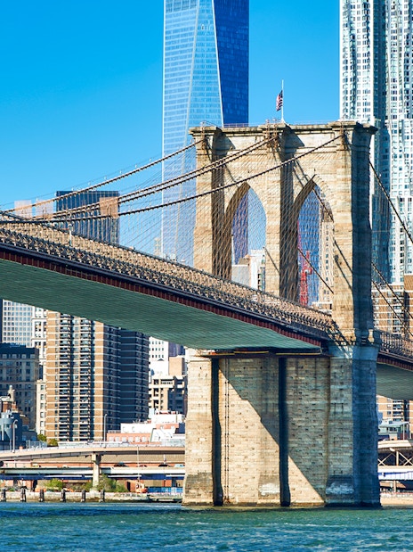 Brooklyn Bridge spanning East River with Manhattan skyline in New York City.
