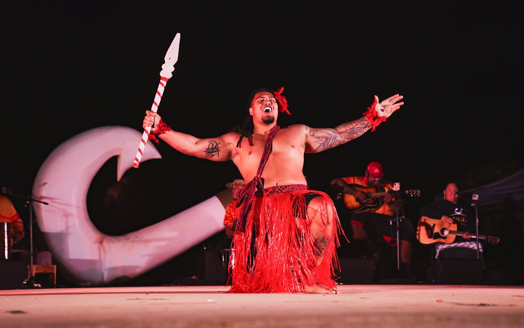 Mauka Warrior performing traditional dance on stage at a Luau.