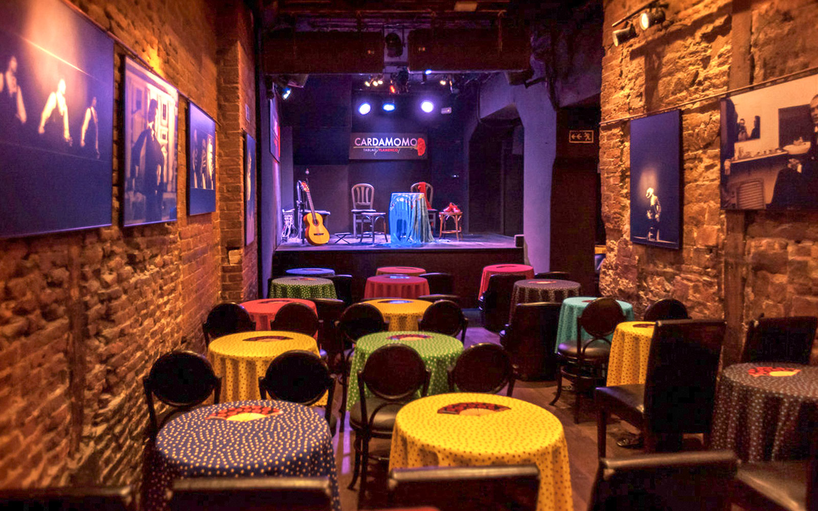 Tablao Cardamomo stage with colorful tables and flamenco guitar in Madrid.