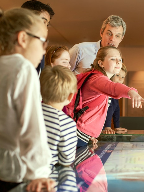Children engaged in an interactive museum exhibit during a guided tour.