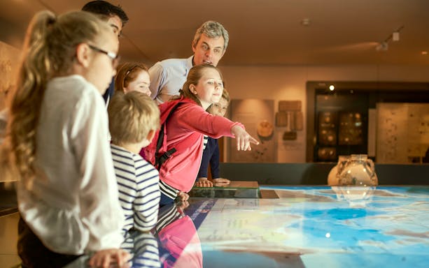 Children engaged in an interactive museum exhibit during a guided tour.