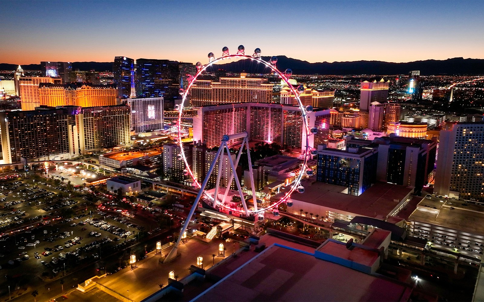 High Roller observation wheel illuminated at night, Las Vegas skyline in background.