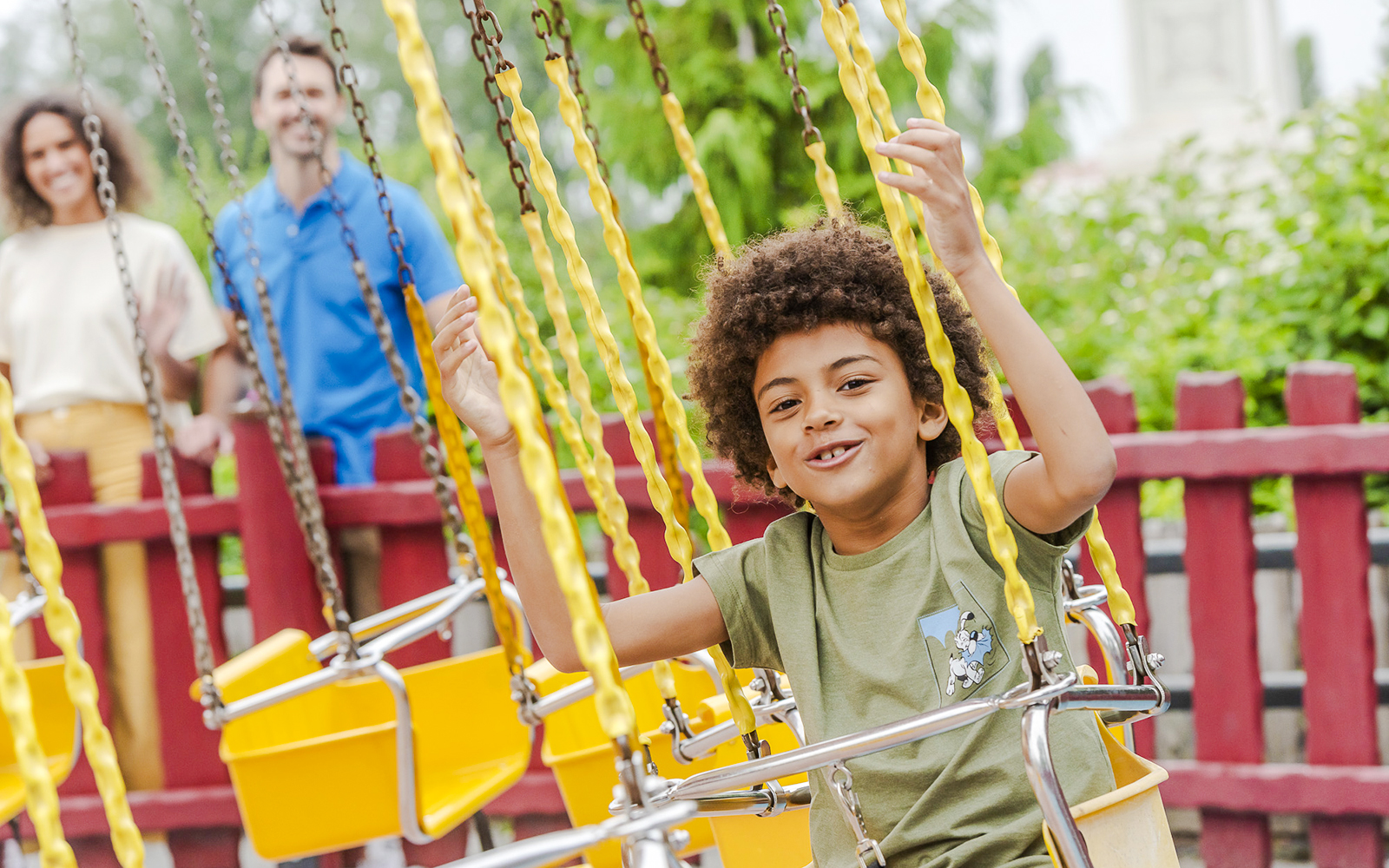 Child enjoying a swing ride at Parc Asterix, France.