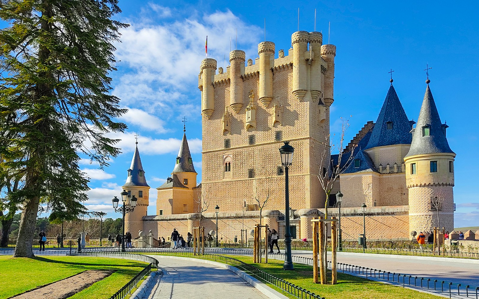 Alcázar de Segovia, Tower of John II with visitors walking nearby.