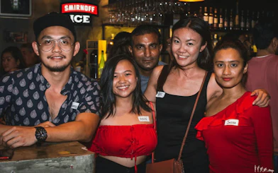 Group enjoying nightlife pub crawl in Dubai bar.