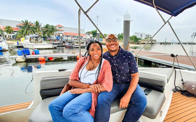 Couple enjoying a boat tour at a marina in Let's Go Kelong.