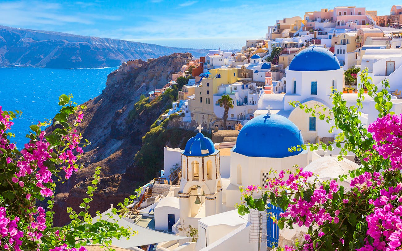 Santorini's blue-domed churches and sea view on a semi-private city tour.