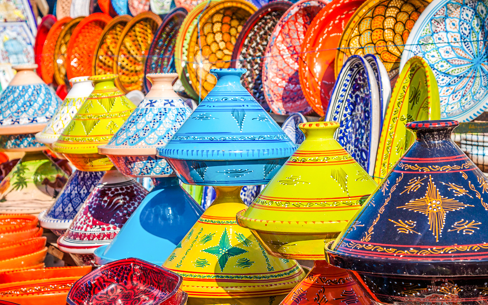 Colorful Moroccan tagines displayed in Marrakesh Medina souks.