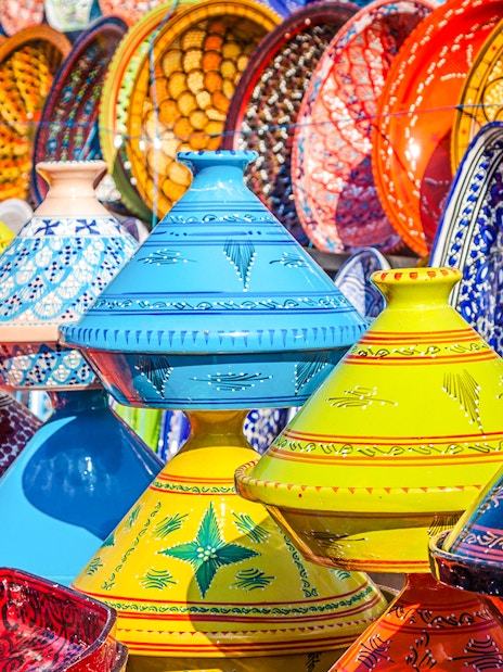 Colorful Moroccan tagines displayed in Marrakesh Medina souks.
