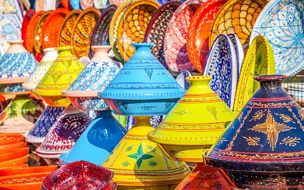 Colorful Moroccan tagines displayed in Marrakesh Medina souks.