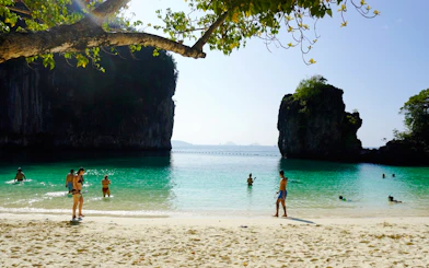 Visitors enjoying the beach and clear waters at Hong Island, Krabi.