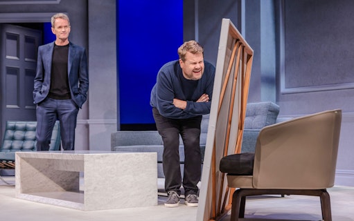 Two actors performing a scene from the Art Broadway show on stage.