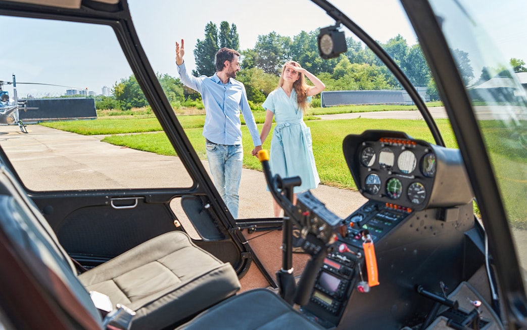 Couple walking towards helicopter on a sunny day.