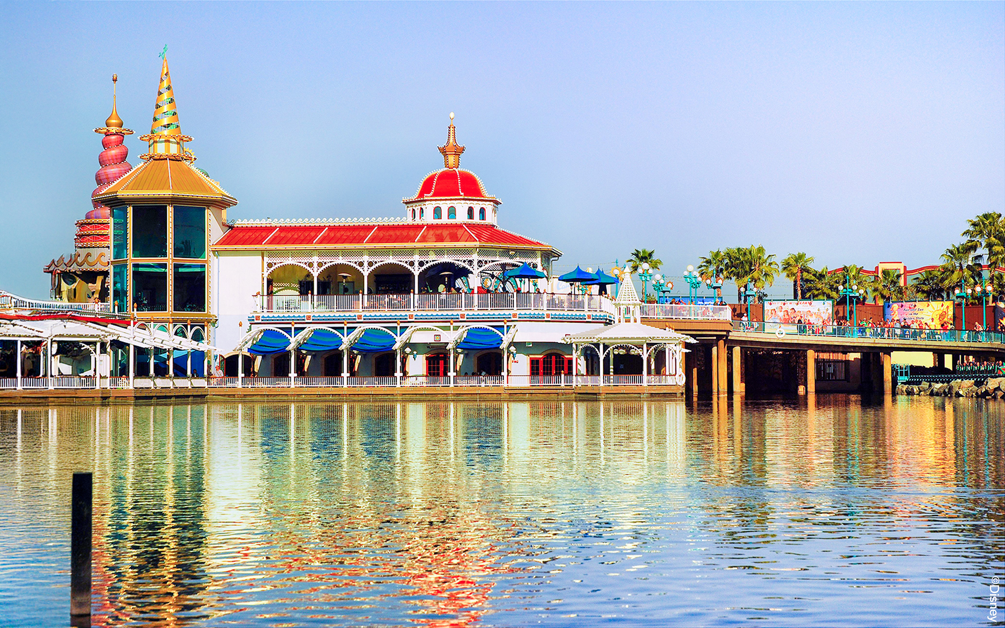 Colorful waterfront building at Disneyland Park, California, reflecting in the water.