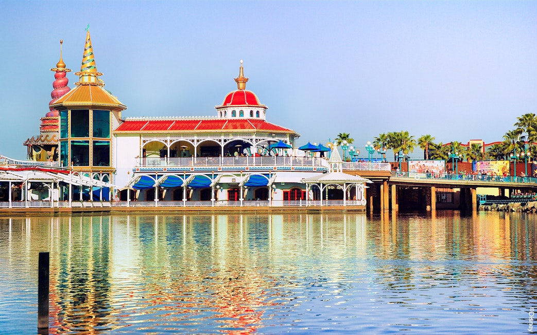 Colorful waterfront building at Disneyland Park, California, reflecting in the water.