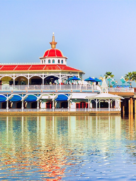 Colorful waterfront building at Disneyland Park, California, reflecting in the water.