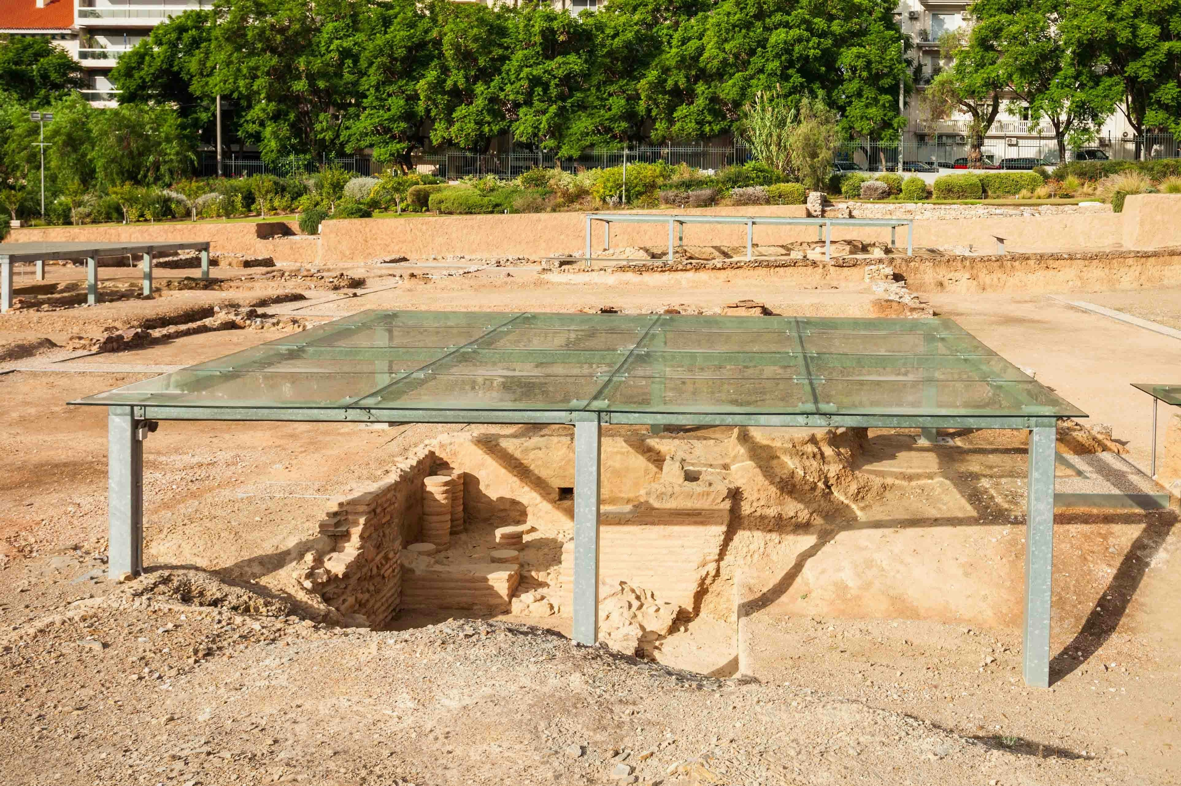 Ancient ruins under glass cover at Acropolis site in Athens.