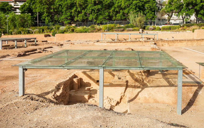 Ancient ruins under glass cover at Acropolis site in Athens.