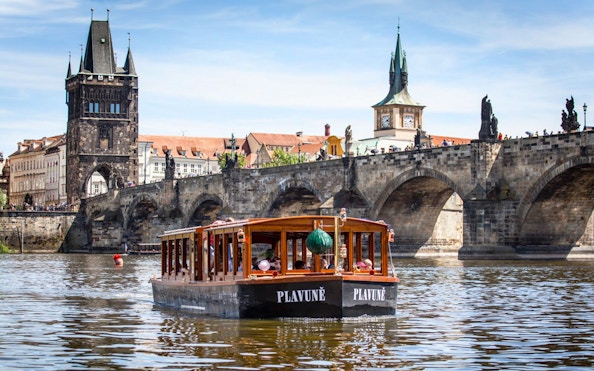 Prague sightseeing boat cruise near Charles Bridge with drink and snack.
