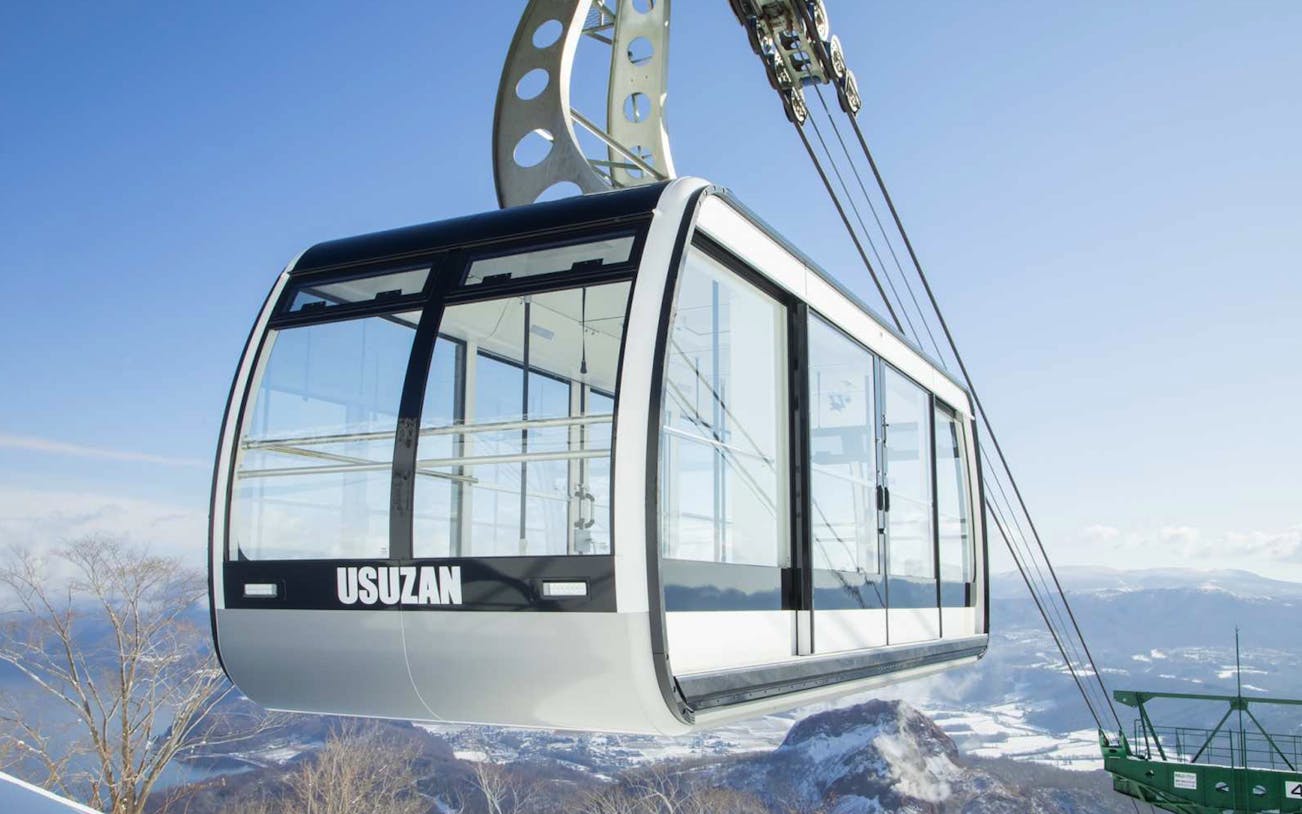 Mt. Usu cable car ascending with scenic mountain views in Japan.