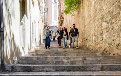 Tourists walking down stone steps in the Jewish Quarter, Girona, Catalonia, Spain.