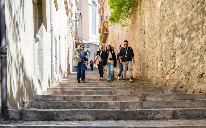 Tourists walking down stone steps in the Jewish Quarter, Girona, Catalonia, Spain.