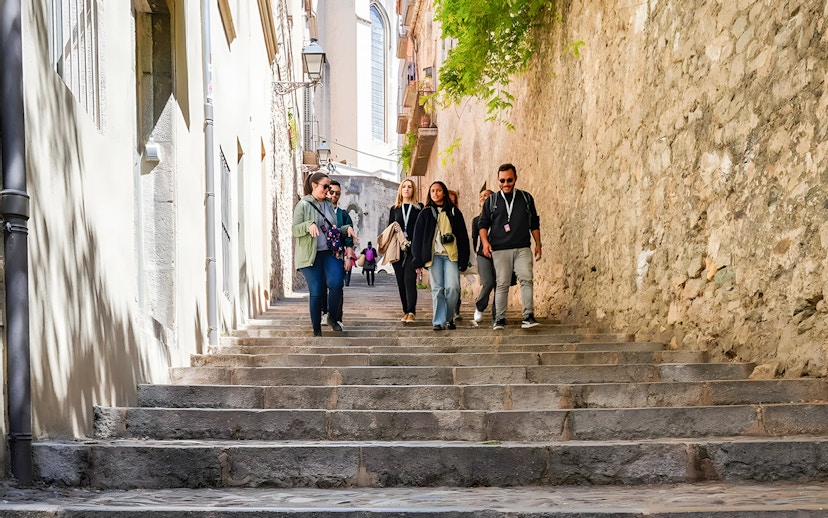 Tourists walking down stone steps in the Jewish Quarter, Girona, Catalonia, Spain.