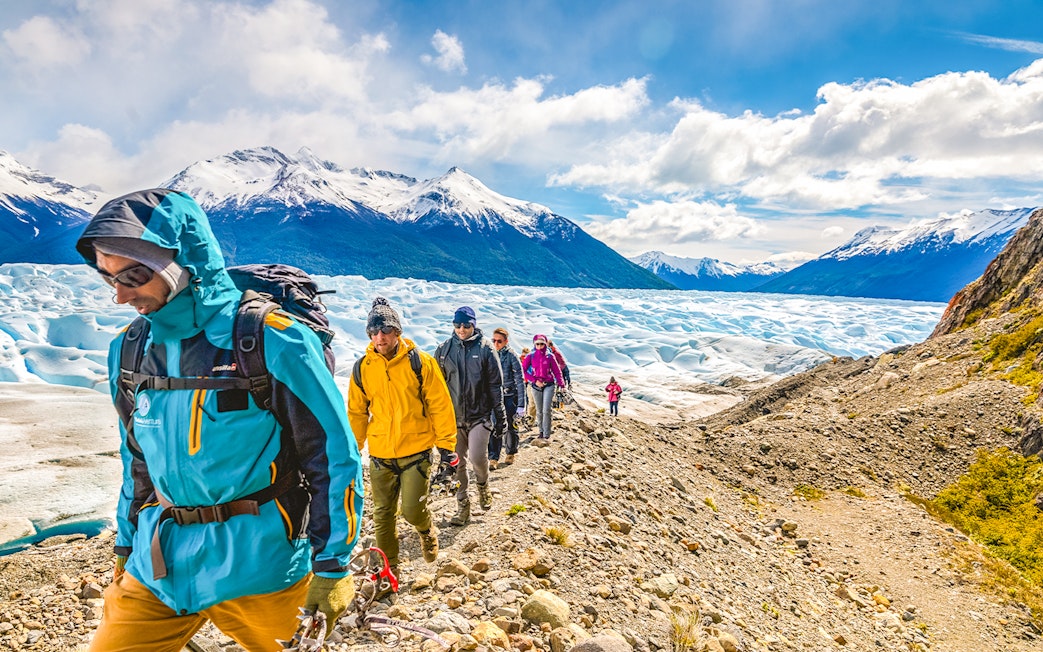 Tourists hiking with a guide on Perito Moreno Glacier, Argentina.