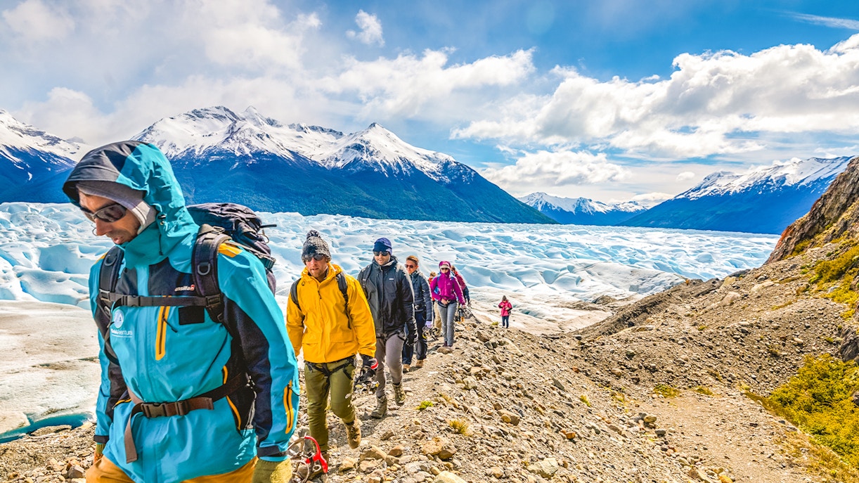 Tourists hiking with a guide on Perito Moreno Glacier, Argentina.