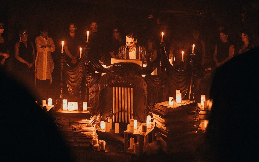 Masquerade Broadway stage performance with actor in mask surrounded by candles.