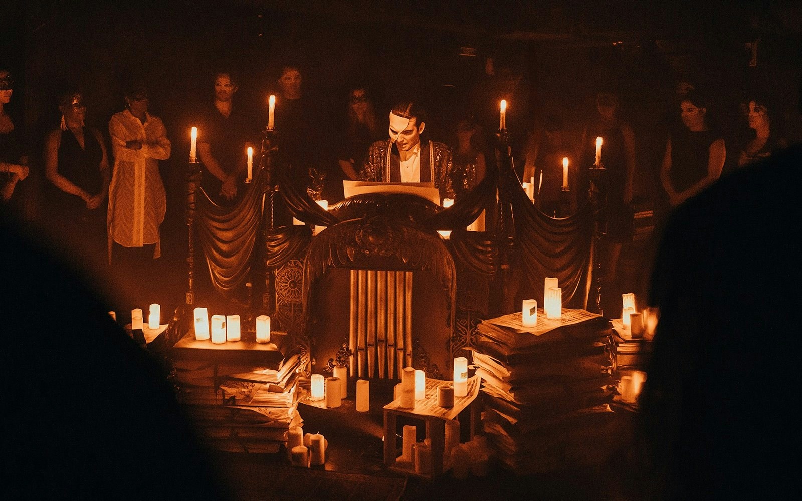 Masquerade Broadway stage performance with actor in mask surrounded by candles.
