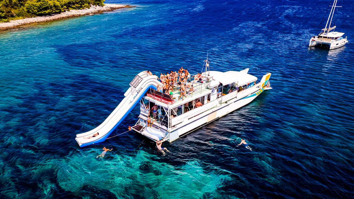 Cruise ship with slide and swimmers during Blue Lagoon tour from Split.