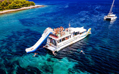 Cruise ship with slide and swimmers during Blue Lagoon tour from Split.