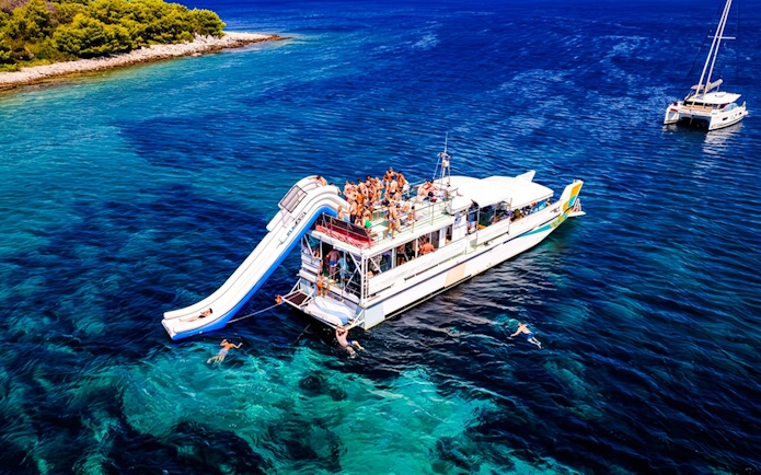 Cruise ship with slide and swimmers during Blue Lagoon tour from Split.
