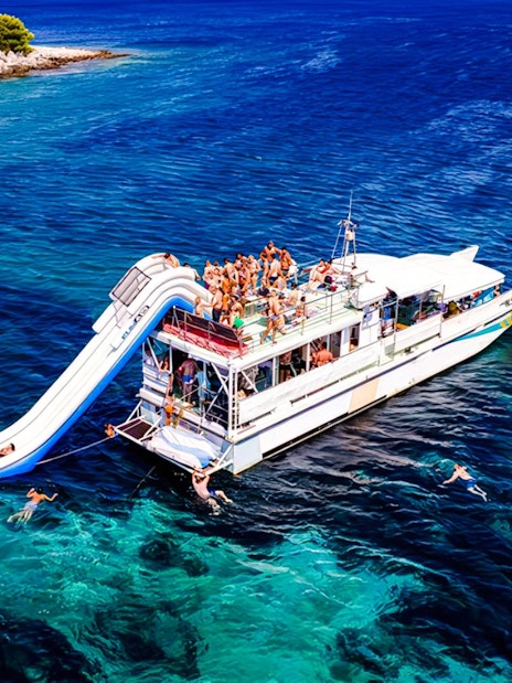 Cruise ship with slide and swimmers during Blue Lagoon tour from Split.